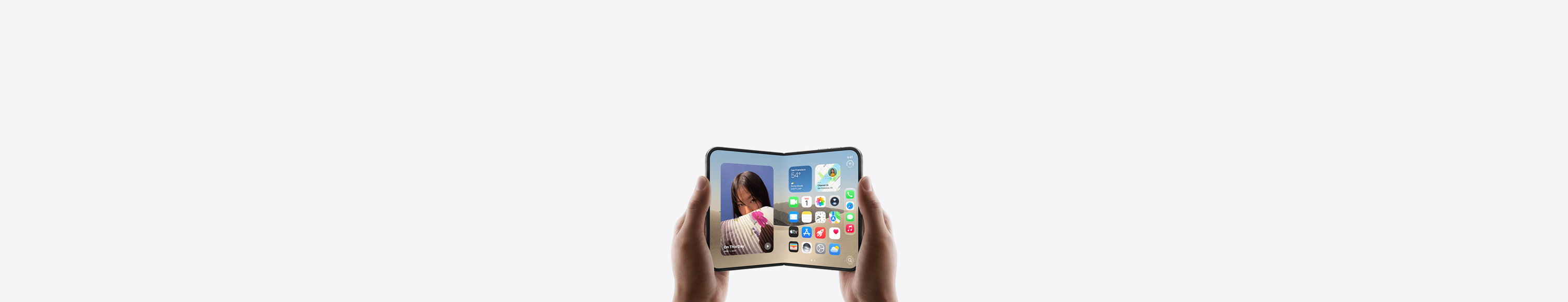 iPhone Duo, tenu par deux mains en mode paysage, déplié, écran interne affichant l’écran d’accueil