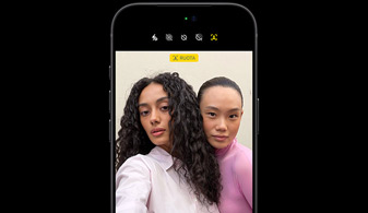 iPhone 18 Pro nero mostrato di fronte, sullo schermo c’è una videochiamata tra due persone in cui viene usato il tracciamento del volto, per dimostrare la funzione “Inquadratura automatica” della fotocamera frontale Center Stage