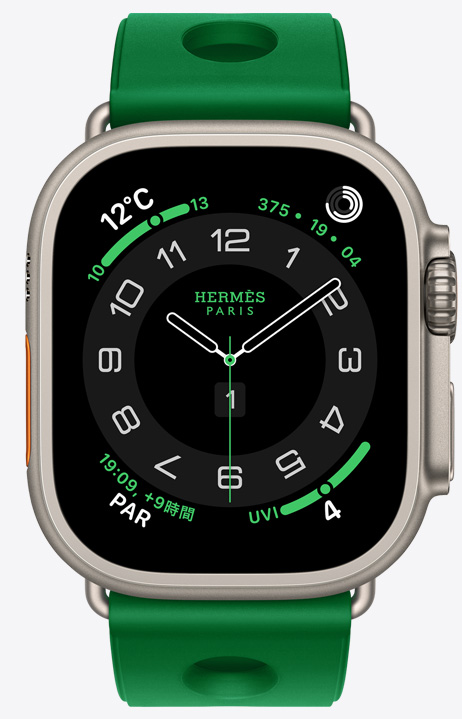ナチュラルチタニウムケースのApple Watch Hermès Ultra 4。アナログデザインのCirculaire文字盤に、時針、分針、秒針と、天気、アクティビティリング、パリ時間、UV指数のコンプリケーションが表示されている。右側面の外観には、Digital Crown、少し突き出たサイドボタンが見えている。ラバー素材を成形し、中央に円形のカットアウトをあしらった、ヴェールヴェルティゴ（ブライトグリーン）のスキュブHダイビングストラップが付いている