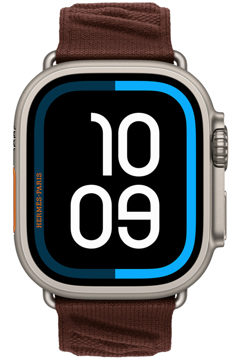 Apple Watch Hermès Ultra 4, Maritime 디지털 시계 페이스 및 내추럴 색상 티타늄 케이스의 오른쪽 옆면 외관에 Digital Crown과 돌출된 측면 버튼을 보여주는 모습. En Mer 밴드, 보르도(다크 브라운) 색상 및 굴곡진 니트 소재를 보여주는 모습