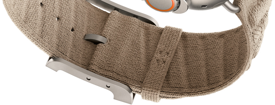 Apple Watch Hermès Ultra 4 En Mer 밴드. 아르질 색상 (탠 계열), 클라스프 아랫면의 디테일 및 굴곡진 니트 소재를 보여주는 모습