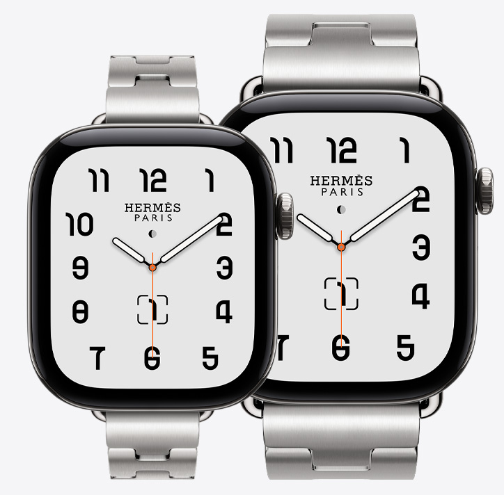 두 개의 Apple Watch Hermès Series 12, 42mm 모델과 46mm 모델, Classic 아날로그 시계 페이스에 시, 분, 초침 및 컴플리케이션에 월령 달력, 날짜가 표시된 모습. 실버 색상 티타늄 케이스로, 42mm 모델은 사티네 색상의 Grand H Fin 밴드와 연결되어 있고, 46mm 모델은 사티네 색상의 Grand H 밴드에 연결되어 있는 모습