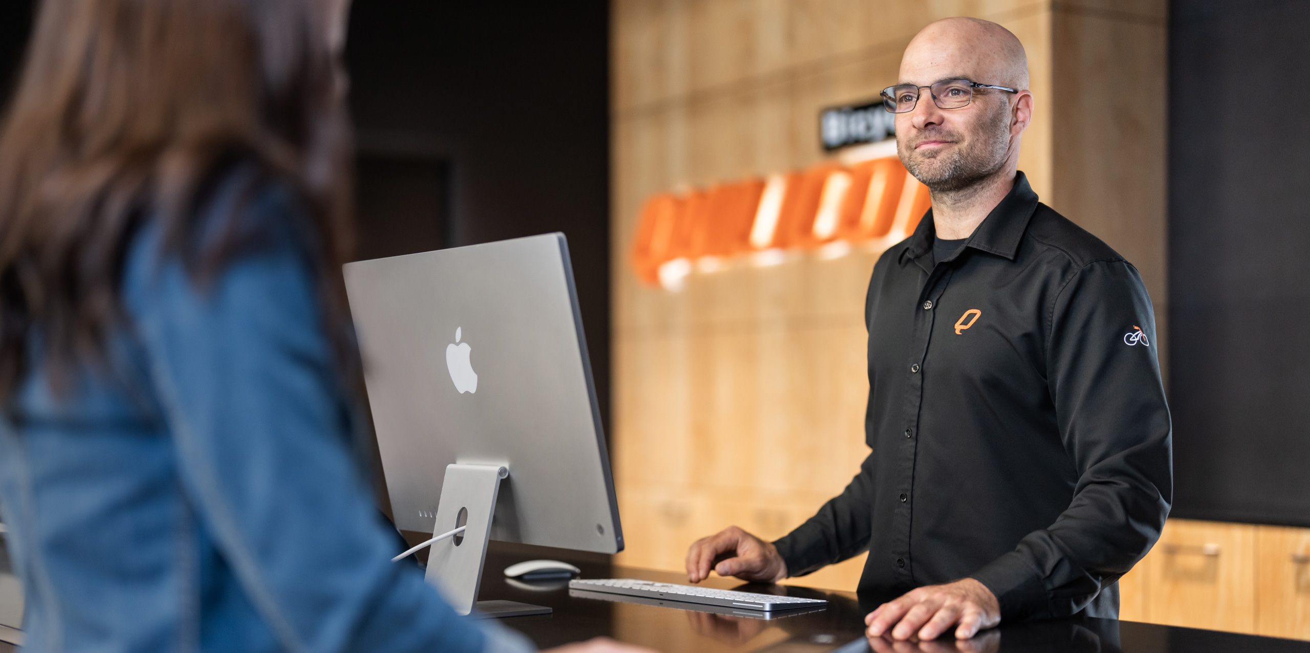 Ein Mitarbeiter von Bicycles Quilicot schließt einen Kundenkauf auf dem iMac ab.