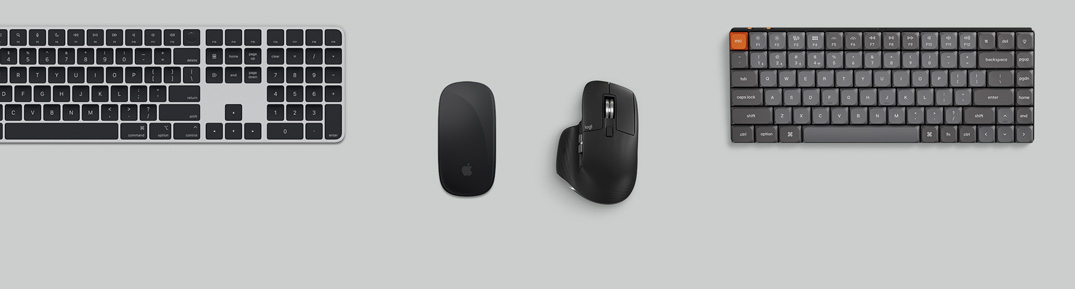 Вид зверху на сріблястий Mac mini, який розміщено на столі поряд із монітором з активним екраном, бездротовими клавіатурами, бездротовими мишами, ігровим контролером і навушниками AirPods Max