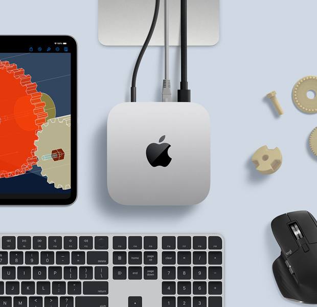 Вид зверху на Mac mini. Поруч із ним на столі лежить чорно-срібляста бездротова клавіатура, чорна бездротова миша та iPad